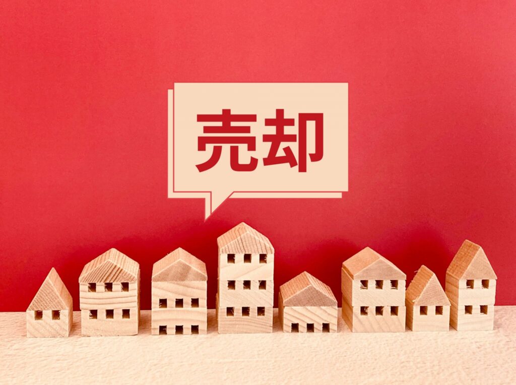 高知の不動産売却をイメージした住宅模型と「売却」の吹き出し
