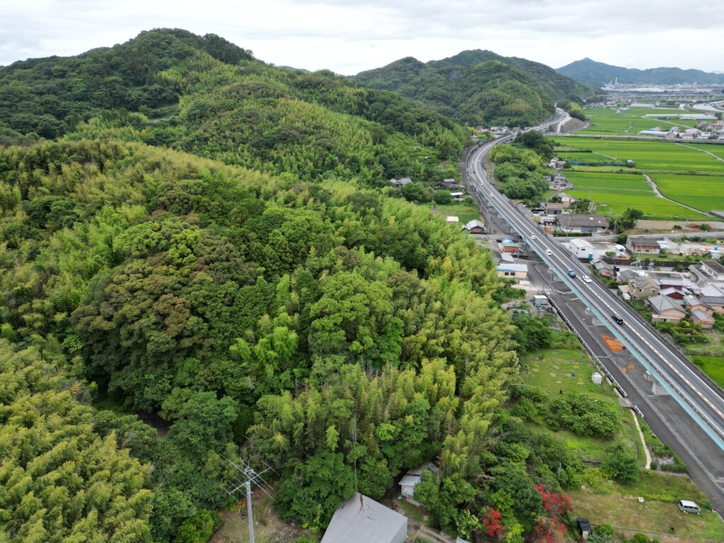 高知県の住宅地に近い山林を上空から撮影した写真。相続前に山林の位置特定や現況確認の重要性を示すイメージ。