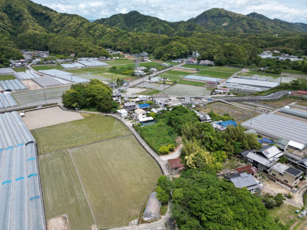 高知県の市街化調整区域にある農地と集落の空撮写真。空き家の引継ぎや建て替え、行政手続きの確認が必要となる場合がある地域